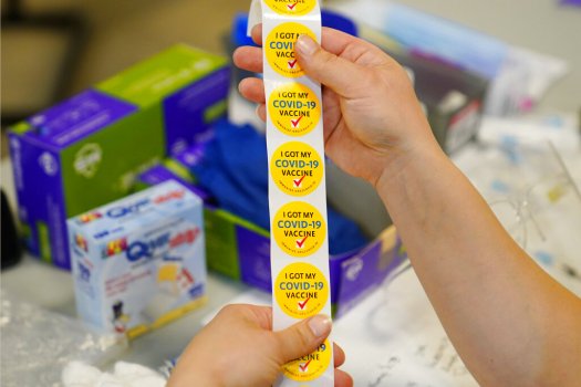 Registered nurse Carol Lennon rolls up a strip of stickers while giving out Pfizer COVID-19 vaccinations at a Montgomery County, Pa. Office of Public Health vaccination clinic at the King of Prussia Mall, Tuesday, May 11, 2021, in King of Prussia, Pa. (Matt Slocum/ The Associated Press)
注册护士卡罗尔·列侬在宾夕法尼亚州蒙哥马利县的一家医院分发辉瑞COVID-19疫苗时,卷着一条贴纸。2021年5月11日,星期二,宾夕法尼亚州普鲁士国王,公共卫生办公室在普鲁士国王购物中心接种疫苗。(马特·斯洛克姆/美联社)