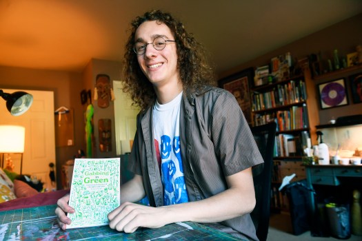 Artist Joey Strain with his latest book, 艺术家乔伊·斯特朗和他的新书《绿色的Gabbing》,在他的家庭工作室里。(bill uhrich -读鹰)
