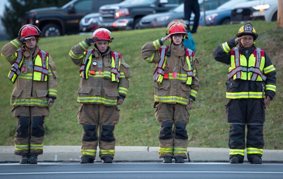 Local firefighters pay their respects Thursday as two hearses pass by with the remains of two New Tripoli firefighters killed Wednesday battling a house fire in West Penn Township, Schuylkill County. (Rick Kintzel - The Morning Call) 周四,当地消防员在两辆灵车经过时表示敬意,灵车上有两名消防员的遗体,他们星期三在斯古基尔县西佩恩镇的一场房屋火灾中丧生。(里克·金泽尔《晨间电话》)