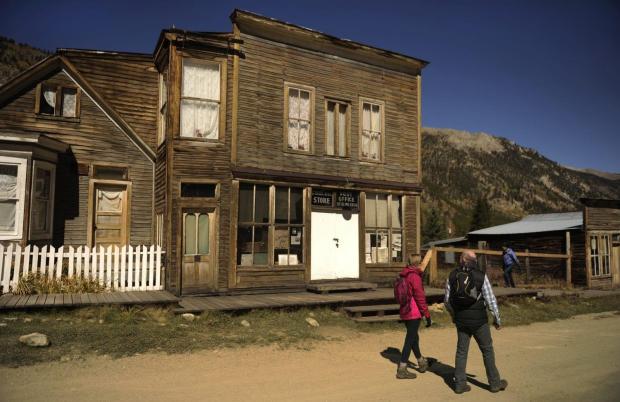 圣艾尔摩有限公司——2013年10月6日:游客探索圣艾尔摩在查菲堡县的鬼城,科罗拉多包括鲜明的兄弟商店和邮局,中心。小镇在9961英尺成立于1880年,曾经有2000人口在金银矿业蓬勃发展。图片由卡尔·格林/《丹佛邮报》