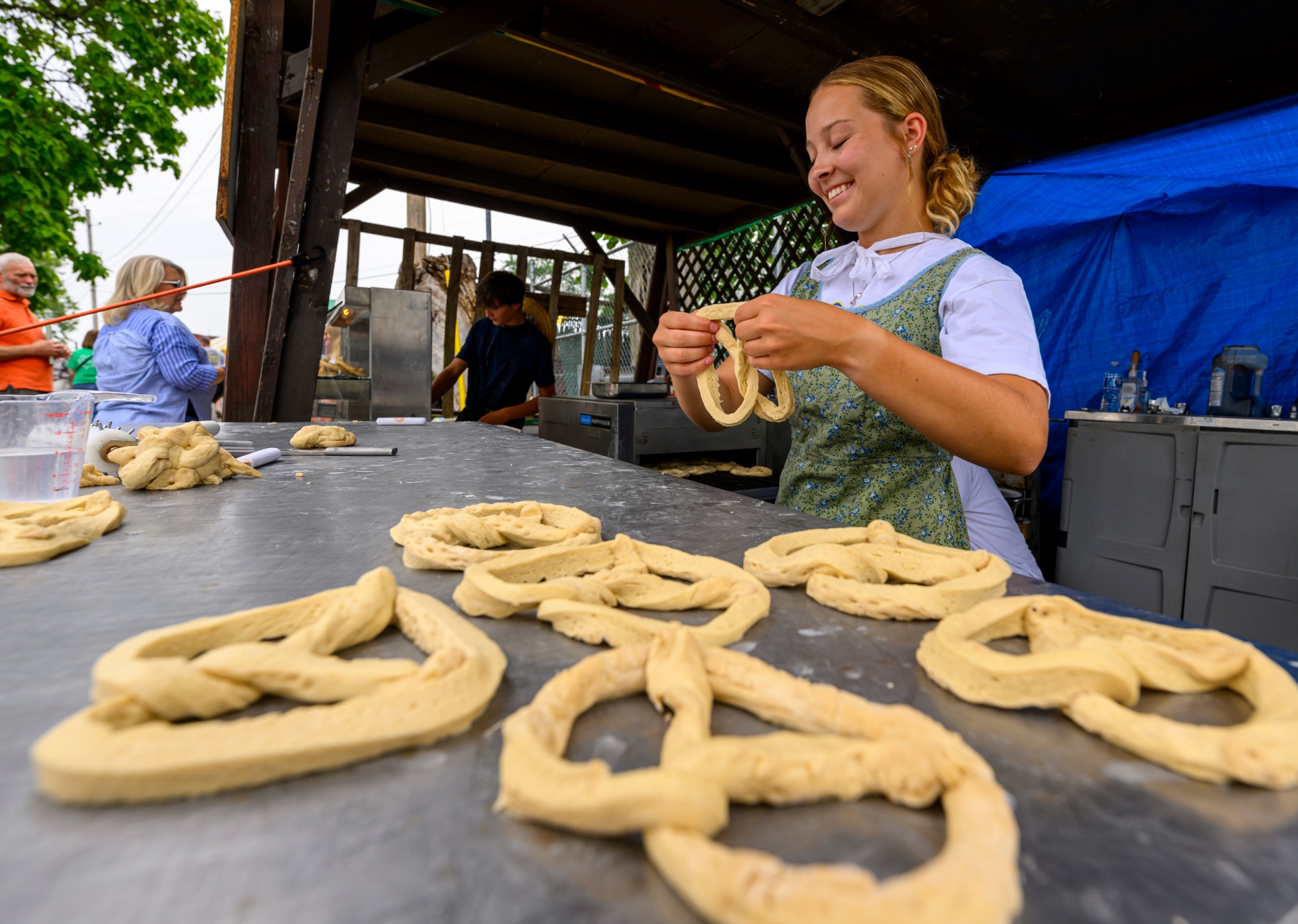 卡乐lafave帮助厨师手工制作的椒盐卷饼星期六,2023年7月1日在库茨敦库茨敦民间节日。库茨敦民间节日是美国最古老的持续经营民俗艺术节和贯穿7月9日,2023年。(4月Gamiz /早上电话)